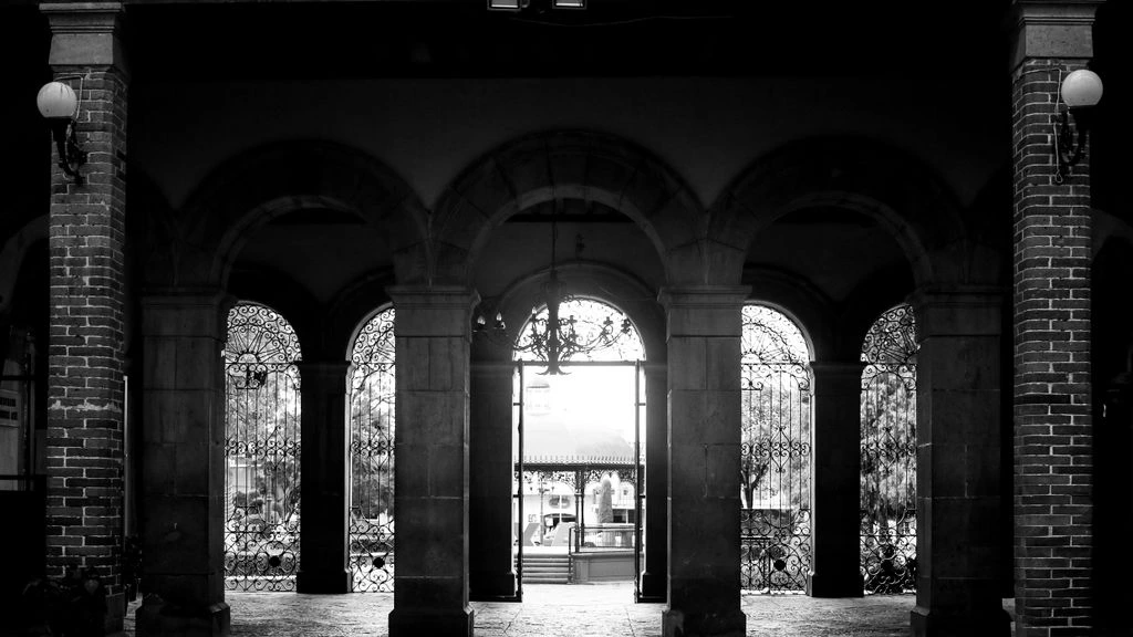 Ingresso dello studio di Corso Como a Milano, scrivania in legno con documenti consolari e una targa bilingue italo-rumena