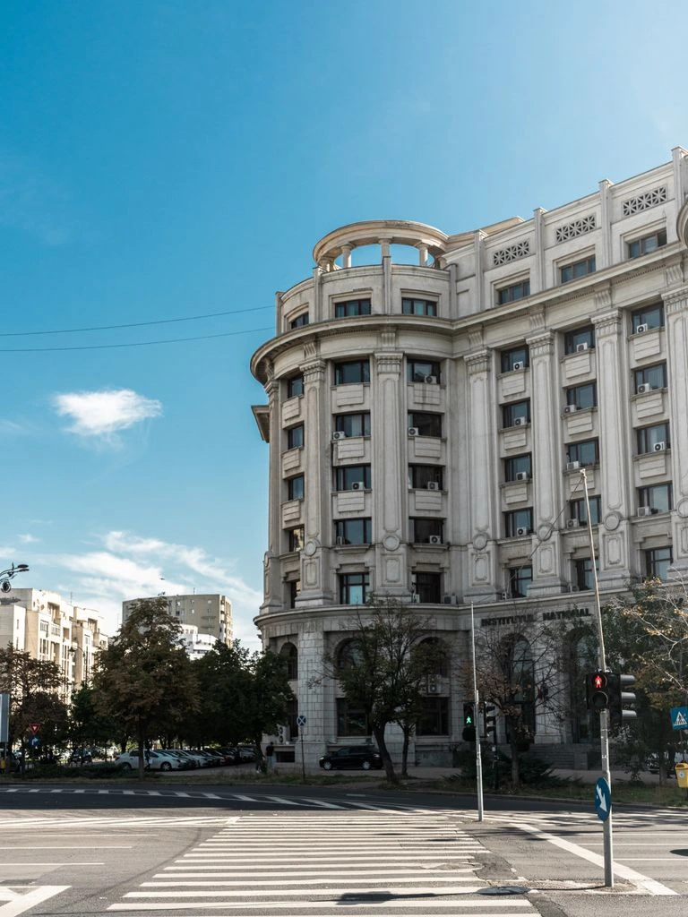 Ufficio di Bucarest con vista su Bulevardul Unirii, scrivania con bandierina italo-rumena e faldoni